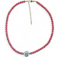 Necklace with pink beads and a central gray pearl on a white background