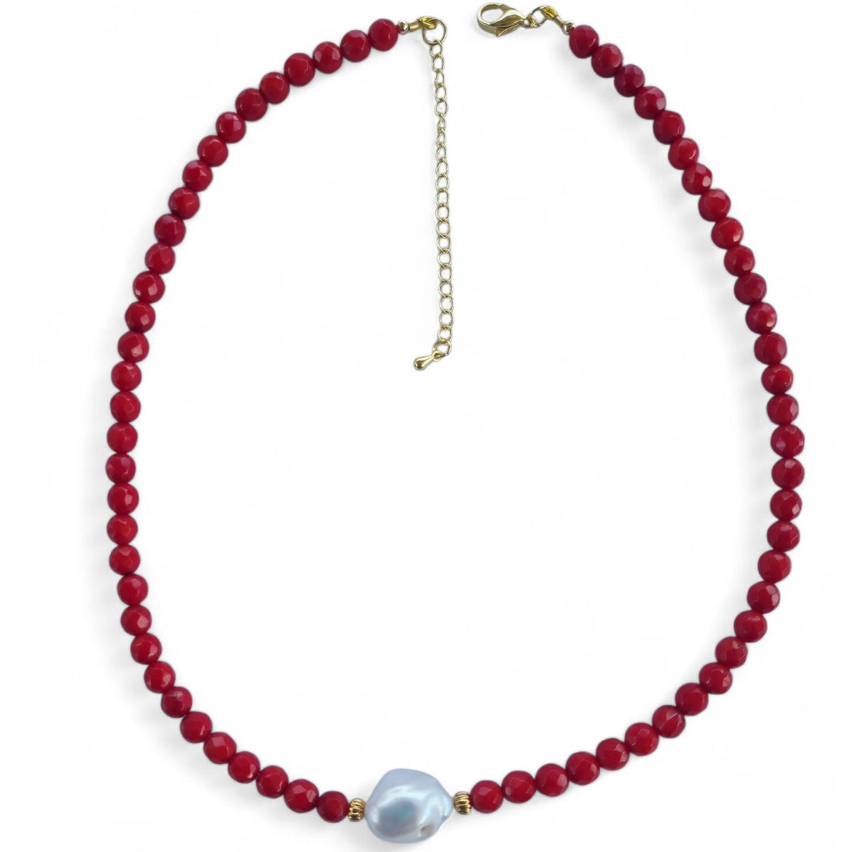 Necklace with red beads and a white keshi pearl on a white background