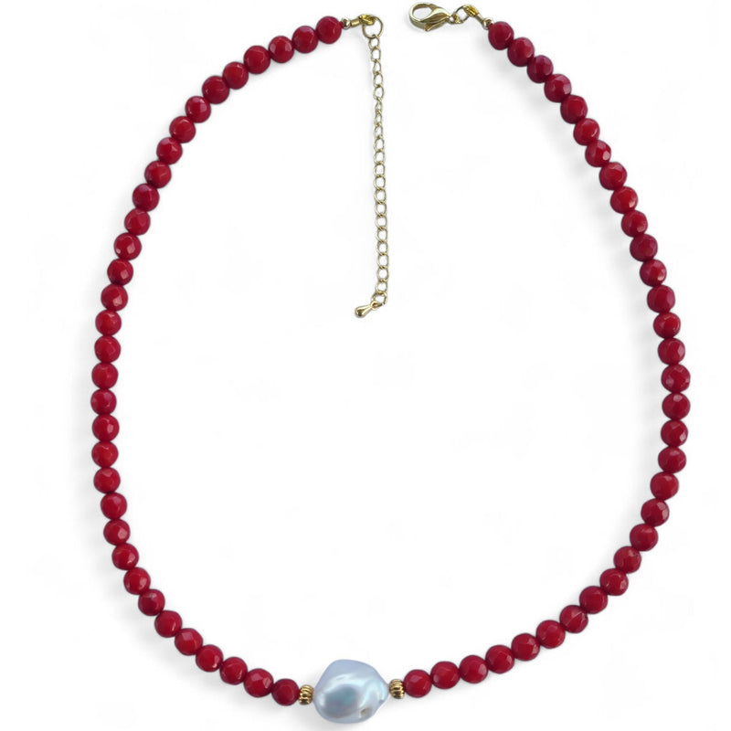 Necklace with red beads and a white keshi pearl on a white background