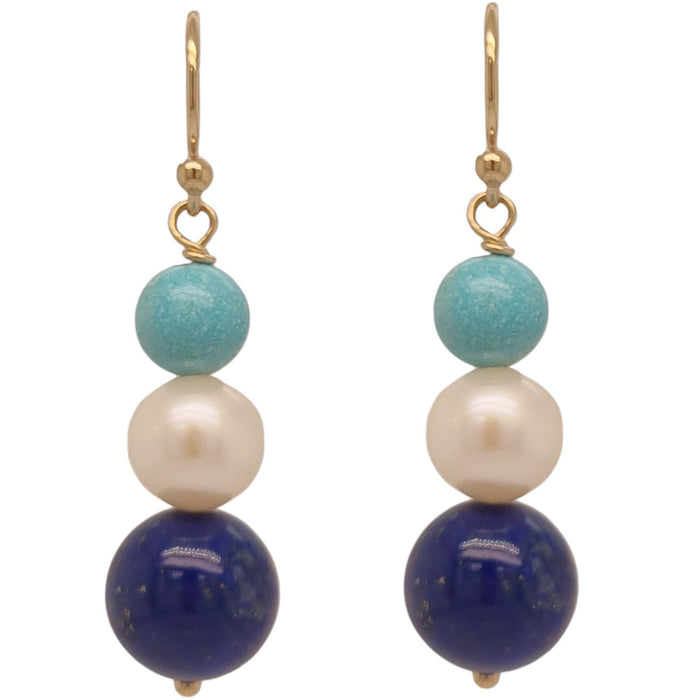 A pair of earrings featuring a tiered design with blue Lapis Lazuli, turquoise, and white freshwater pearl, all hanging from gold-colored hooks.