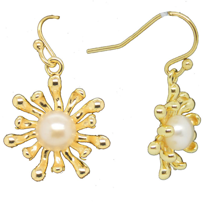 A pair of gold earrings featuring a freshwater pearl at the center with anemone arms extending out in a floral pattern.