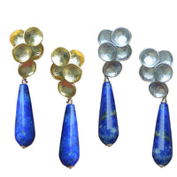 A set of lapis lazuli earrings with gold and silver options, featuring a teardrop stone with a floral-like top in gold or silver, mounted on sterling silver pins.